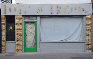 Symbolbid: Geschlossenens Geschäft mit verhängtem Schaufenster symbolisiert die Insolvenz der Firma