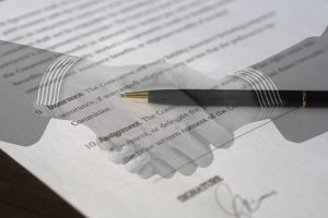 Symbolbild: Handschlag vor einem Vertragsdokument symbolisiert Personenhandelsgesellschaften