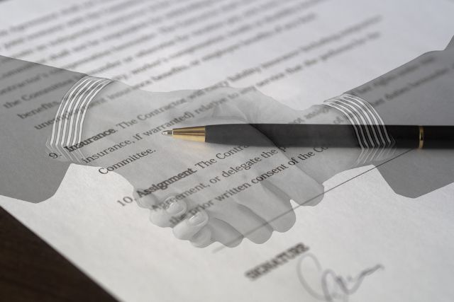 Symbolbild: Handschlag vor einem Vertragsdokument symbolisiert Personenhandelsgesellschaften