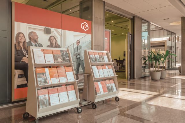Symbolbild: Modernes Bürogebäude mit Prospektständern symbolisiert Anforderungen Wertpapierprospekte